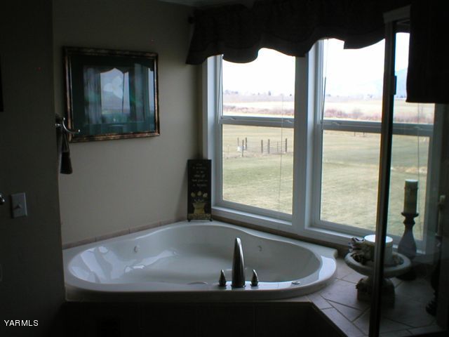 211 Sharp Road Tieton, WA 98947 - Photo 8 of 14 a bath tub sitting in a bathroom next to a window