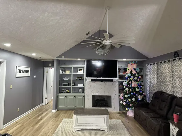 a living room with furniture a flat screen tv and a fireplace