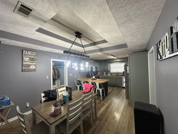 a view of a dining room with furniture wooden floor and a chandelier