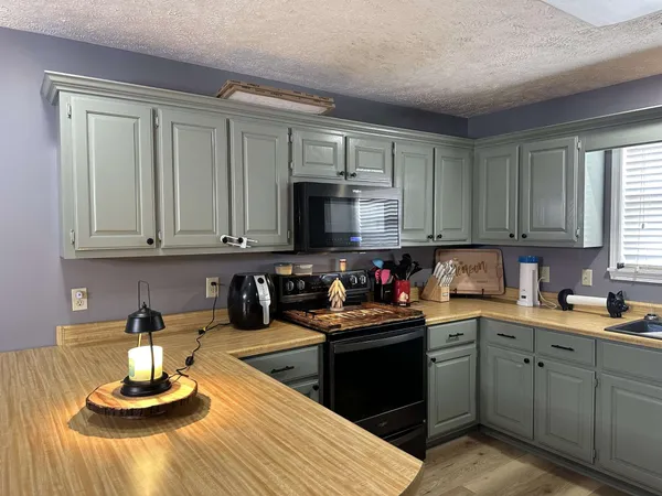 a kitchen with a stove a microwave and wooden cabinets