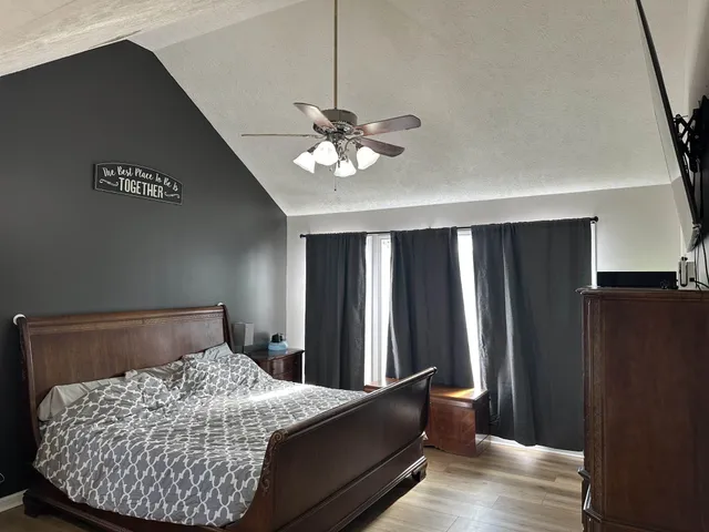 a bedroom with a bed and a ceiling fan