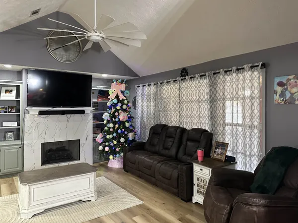 a living room with furniture a flat screen tv and a fireplace