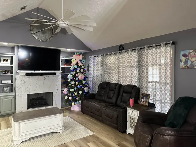 a living room with furniture a flat screen tv and a fireplace