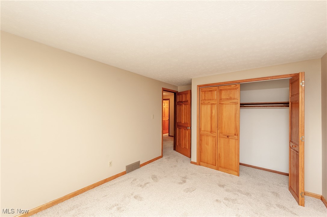 27680 Dunford Road Westlake, OH 44145 - Photo 18 of 31 Unfurnished bedroom with light carpet and a closet