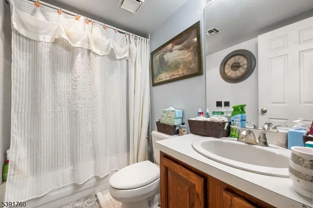 a bathroom with a toilet a sink and a shower curtain