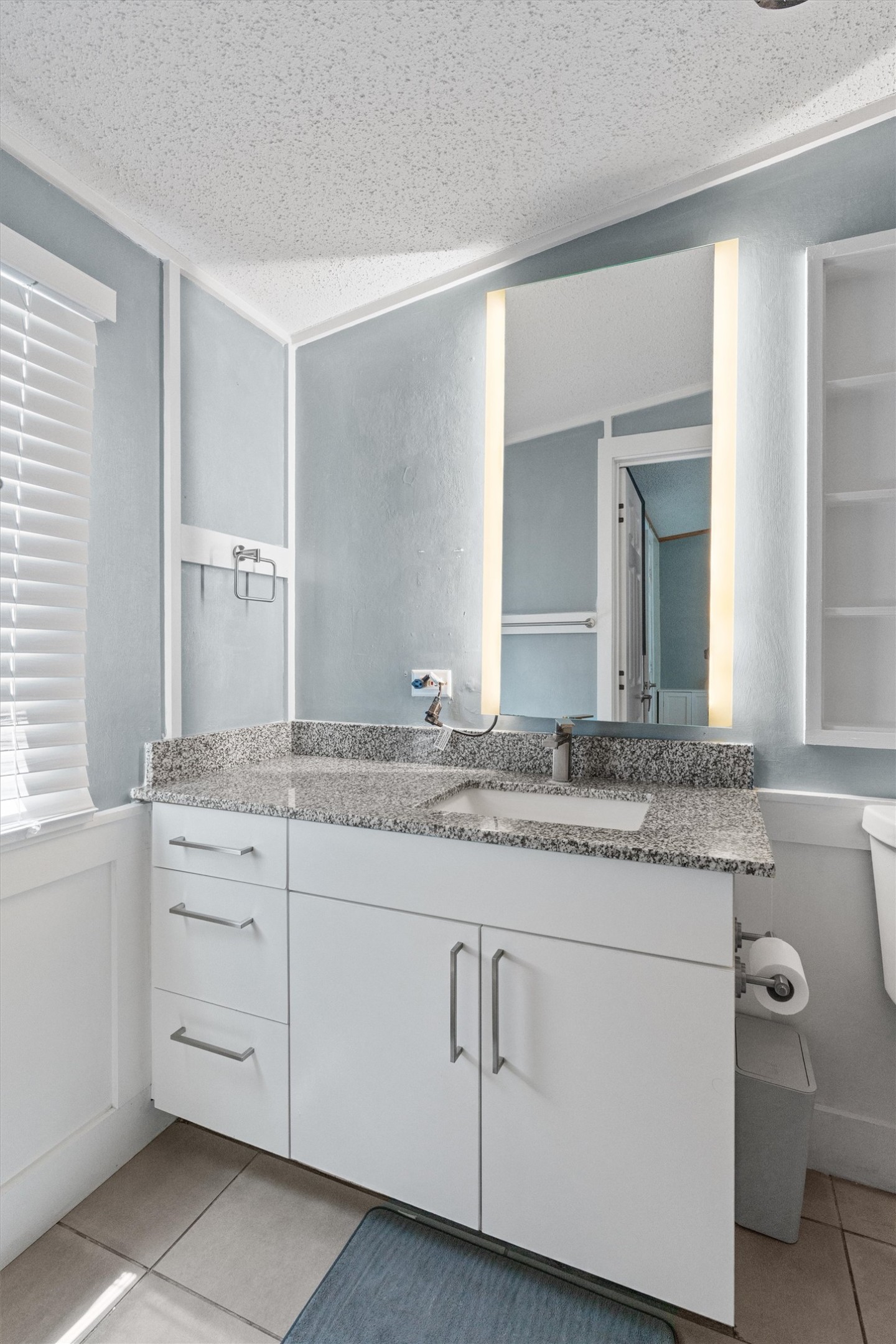218 Boxcar Path Kyle, TX 78640 - Photo 7 of 21 A well-lit bathroom vanity features a stone counter and sleek modern cabinetry.