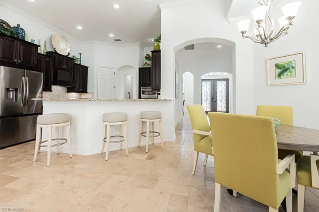 a kitchen with a dining table chairs stainless steel appliances and cabinets