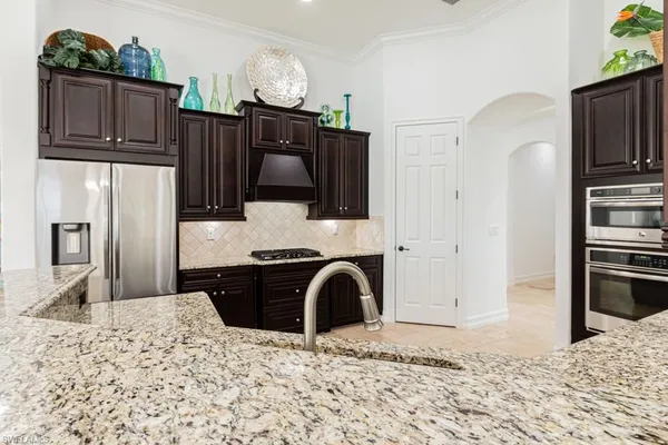 a kitchen with granite countertop a sink stainless steel appliances and cabinets