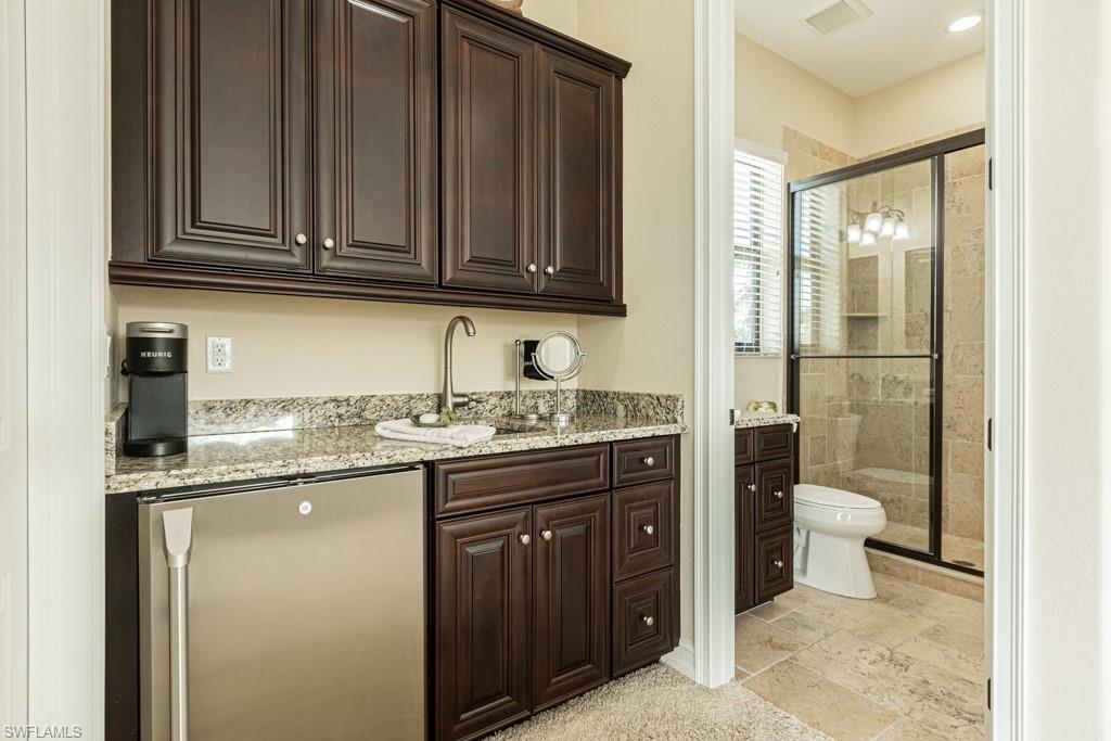 3273 Runaway Lane Naples, FL 34114 - Photo 29 of 45 a bathroom with a granite countertop toilet sink and mirror