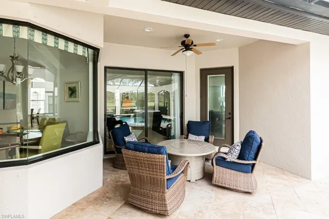 a living room with patio furniture and a floor to ceiling window