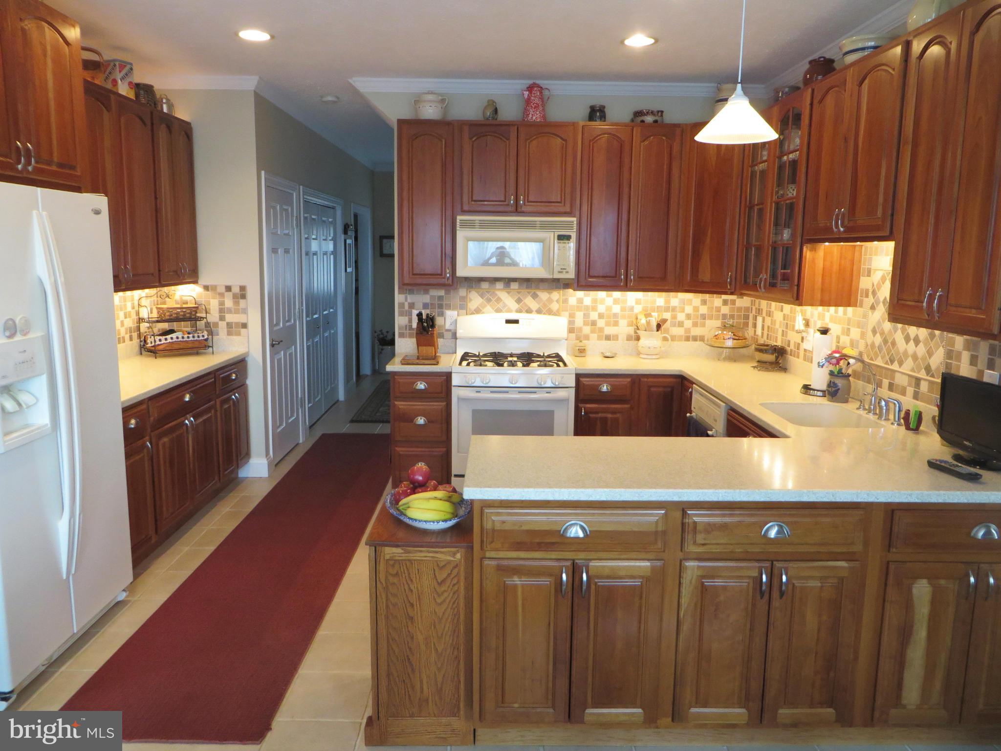 16745 St Jeromes Neck Road Dameron, MD 20628 - Photo 4 of 30 Cherry cabinets and ceramic tile floor, backsplash