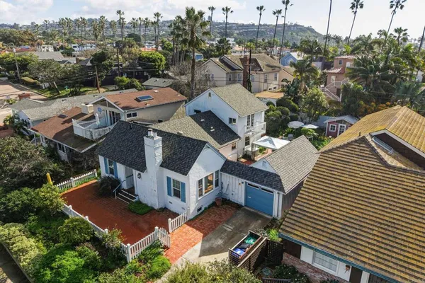 an aerial view of a house with a yard garage lake and outdoor seating