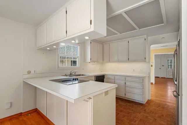 a kitchen that has a sink a stove and cabinets