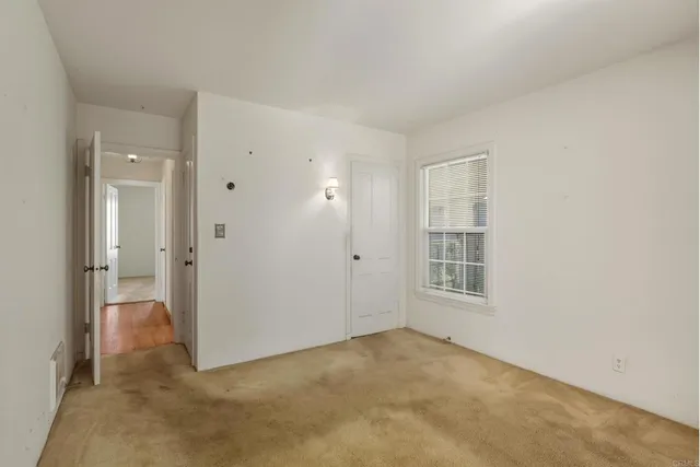 an empty room with windows and closet