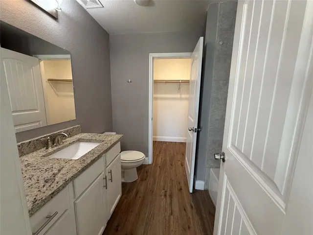 a bathroom with a granite countertop sink toilet and shower curtains