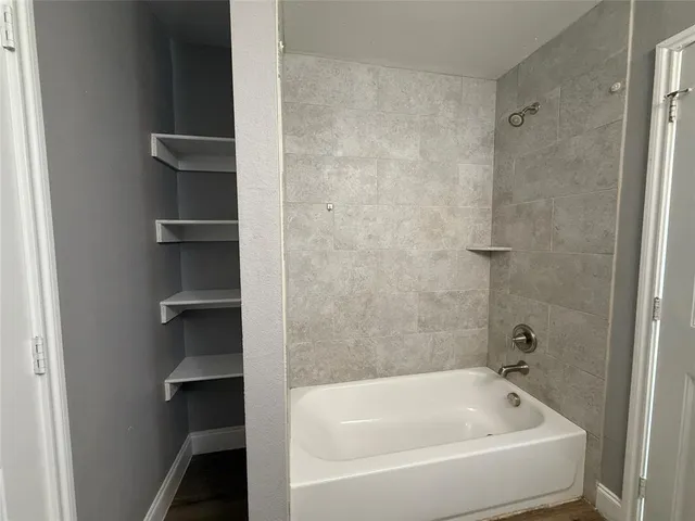 a white bath tub sitting next to a shower