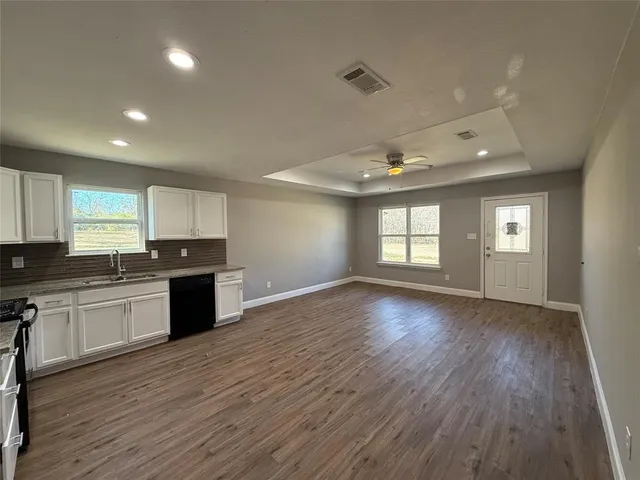 a large kitchen with hardwood floor and a window