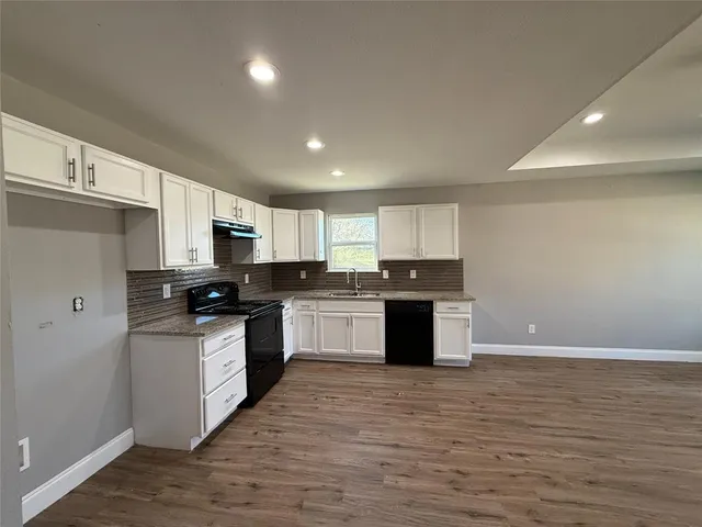 a large kitchen with stainless steel appliances granite countertop a stove and a sink