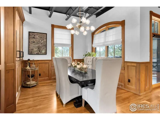 a roof deck with table and chairs and potted plants