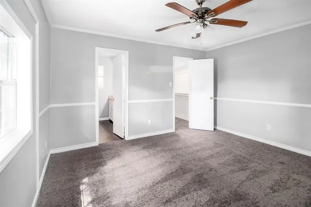 an empty room with closet and windows