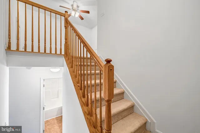 an empty room with a window and a chandelier fan
