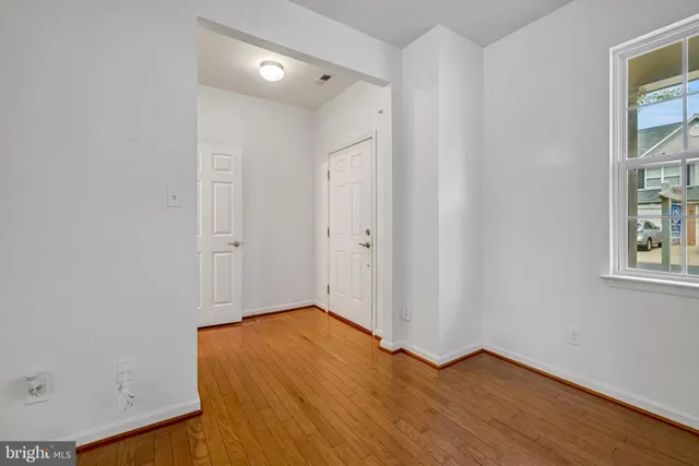 a view of empty room with wooden floor