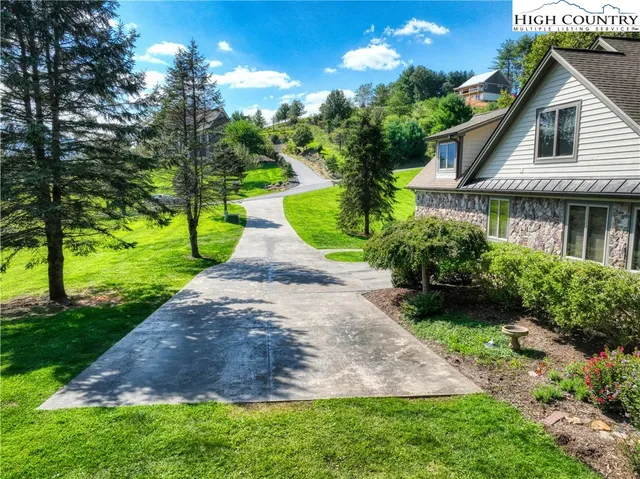 a view of a house with a yard and potted plants