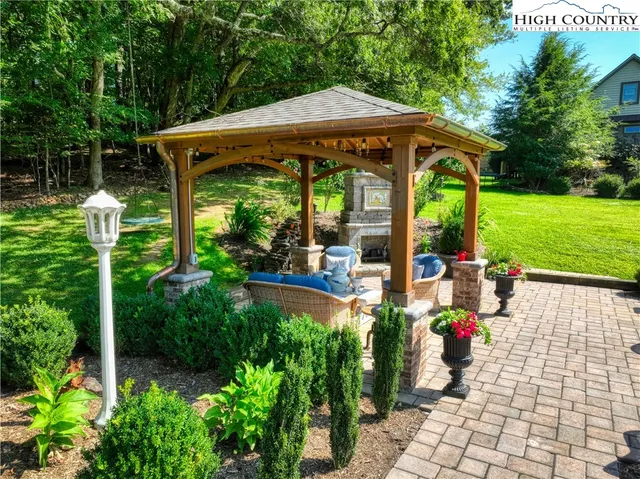 a view of a patio with table and chairs under an umbrella