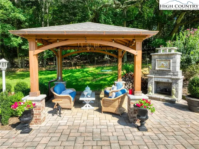 a patio with a table and chairs and potted plants