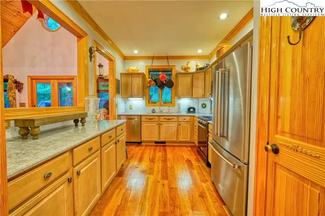 a large kitchen with stainless steel appliances granite countertop a sink and cabinets
