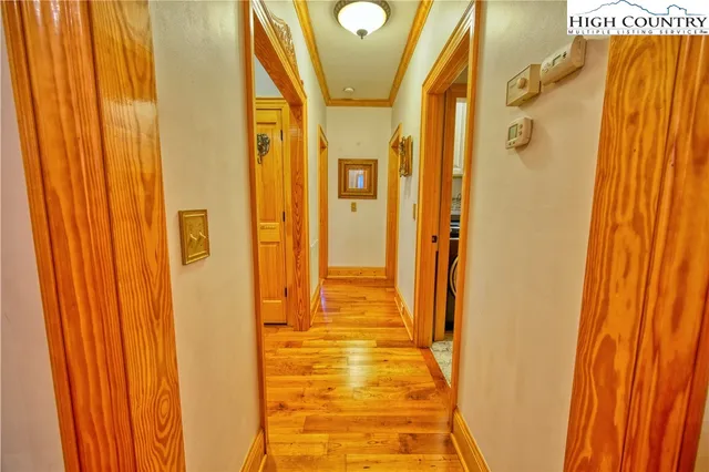 a view of a hallway with wooden floor and staircase