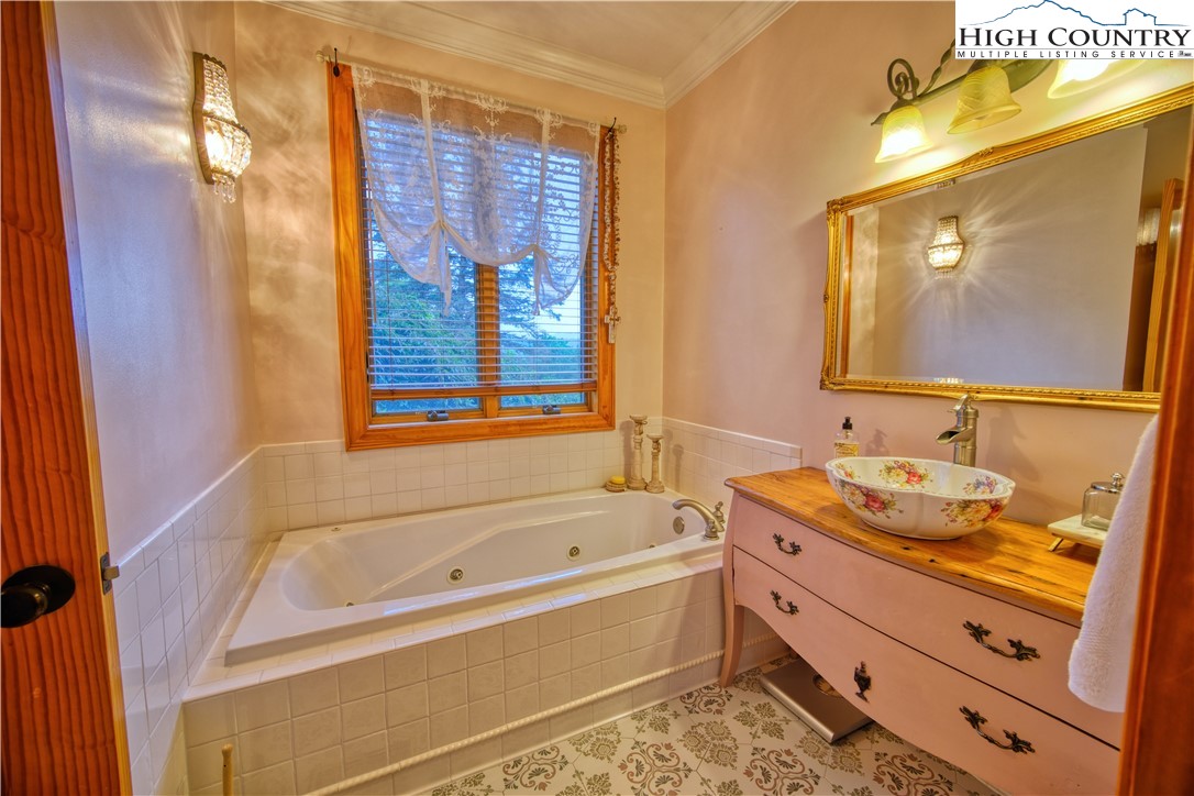 330 Crain Branch Lane Jefferson, NC 28640 - Photo 38 of 45 a bathroom with a granite countertop sink and a bathtub