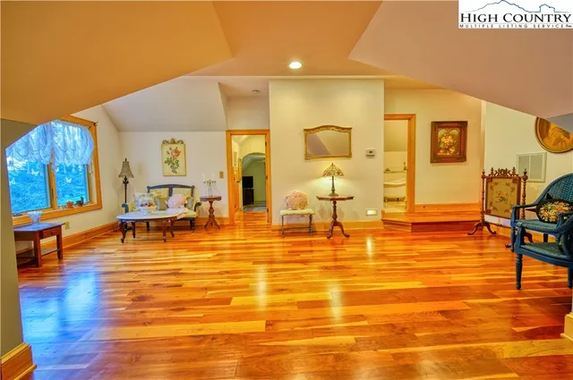 a living room with chairs and wooden floor