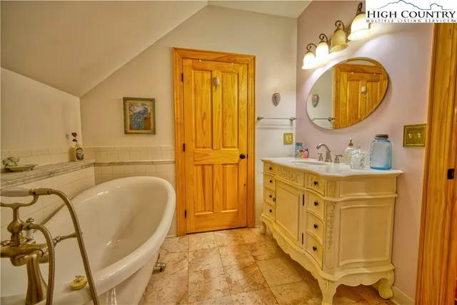 a bathroom with a tub sink and mirror