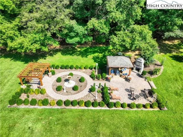 a view of a white house with a big yard and potted plants