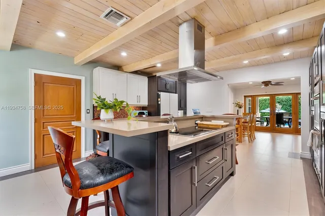 a living room with furniture and a large window with kitchen view