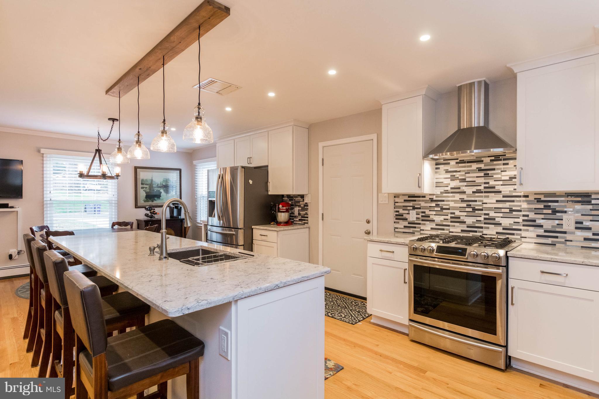239 Ridgeway Road Catonsville, MD 21228 - Photo 1 of 30 a kitchen with stainless steel appliances kitchen island granite countertop a stove a sink dishwasher and a refrigerator with wooden floor