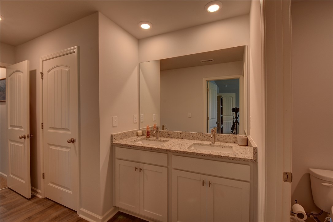 220 Clinkscales Road Anderson, SC 29624 - Photo 20 of 33 A spacious double vanity with granite counters features recessed lighting and durable wood look flooring.
