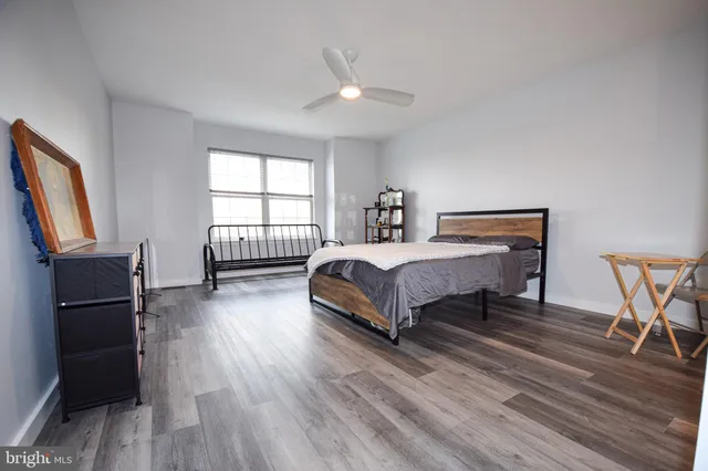 a bedroom with a bed a flat screen tv and a window