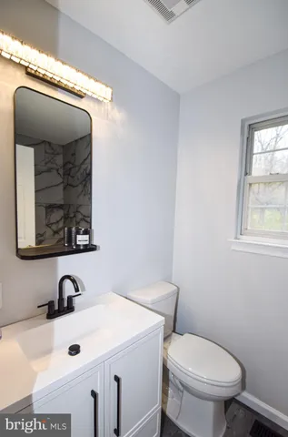a bathroom with a toilet sink and mirror