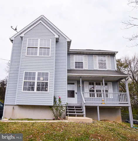 a view of a white house with large windows and a small yard