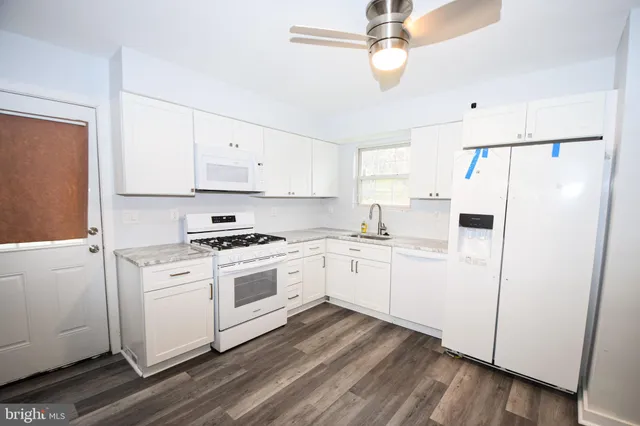 a kitchen with white cabinets and white appliances