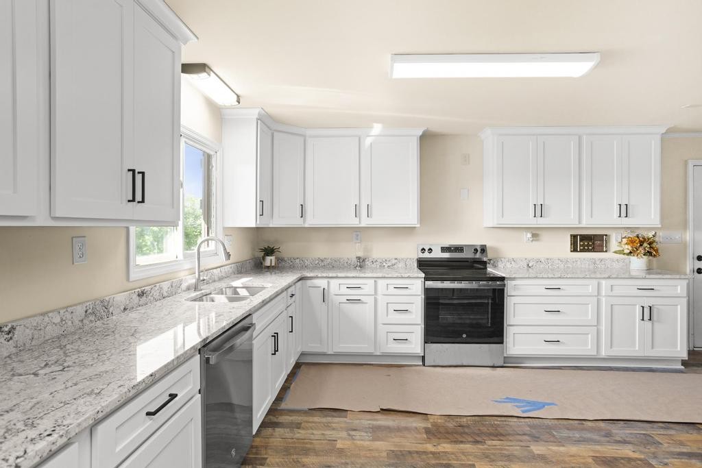 1029 Robertson Road Gallatin, TN 37066 - Photo 9 of 62 a large white kitchen with granite countertop a stove a sink a window and white cabinets