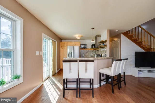 a kitchen with a refrigerator a stove and a wooden floor