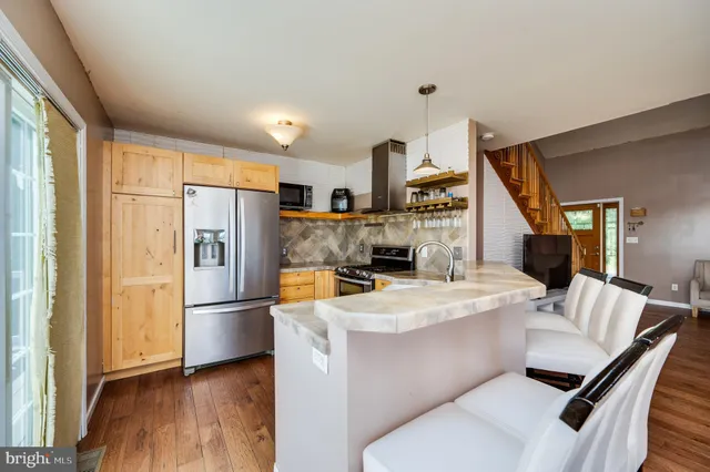 a kitchen with stainless steel appliances granite countertop a refrigerator a stove and a sink