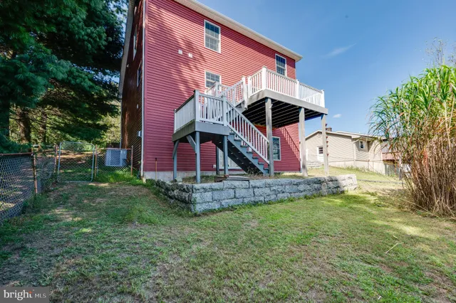 a view of a backyard with a large tree and wooden fence