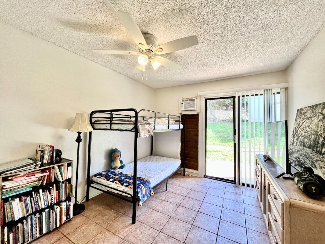 4701 Kawaihau Road, Unit L101 Kapaa, HI 96746 - Photo 9 of 12 a bedroom with furniture and a flat screen tv