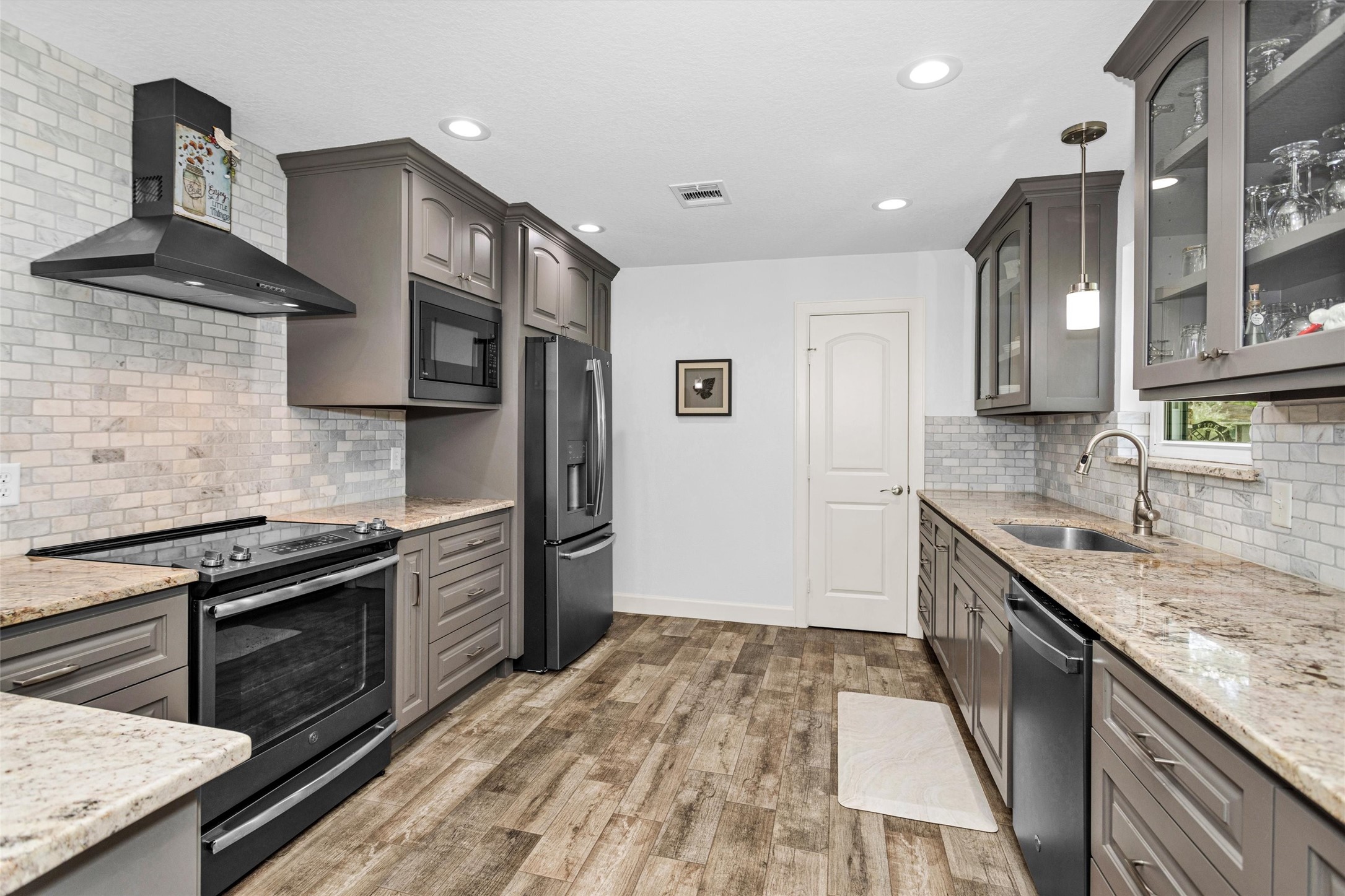 4402 Spears Road Manvel, TX 77578 - Photo 18 of 38 a kitchen with stainless steel appliances granite countertop a sink stove and refrigerator