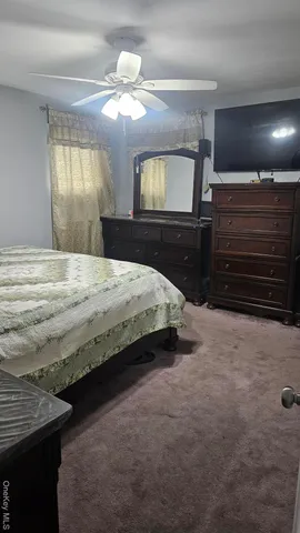 a bedroom with a bed and a mirror on dresser
