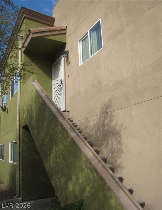 1844 North Decatur Boulevard, Unit 204 Las Vegas, NV 89108 - Photo 3 of 8 A striking exterior showcases a stucco finish with a prominent staircase leading to an upper-level entrance.